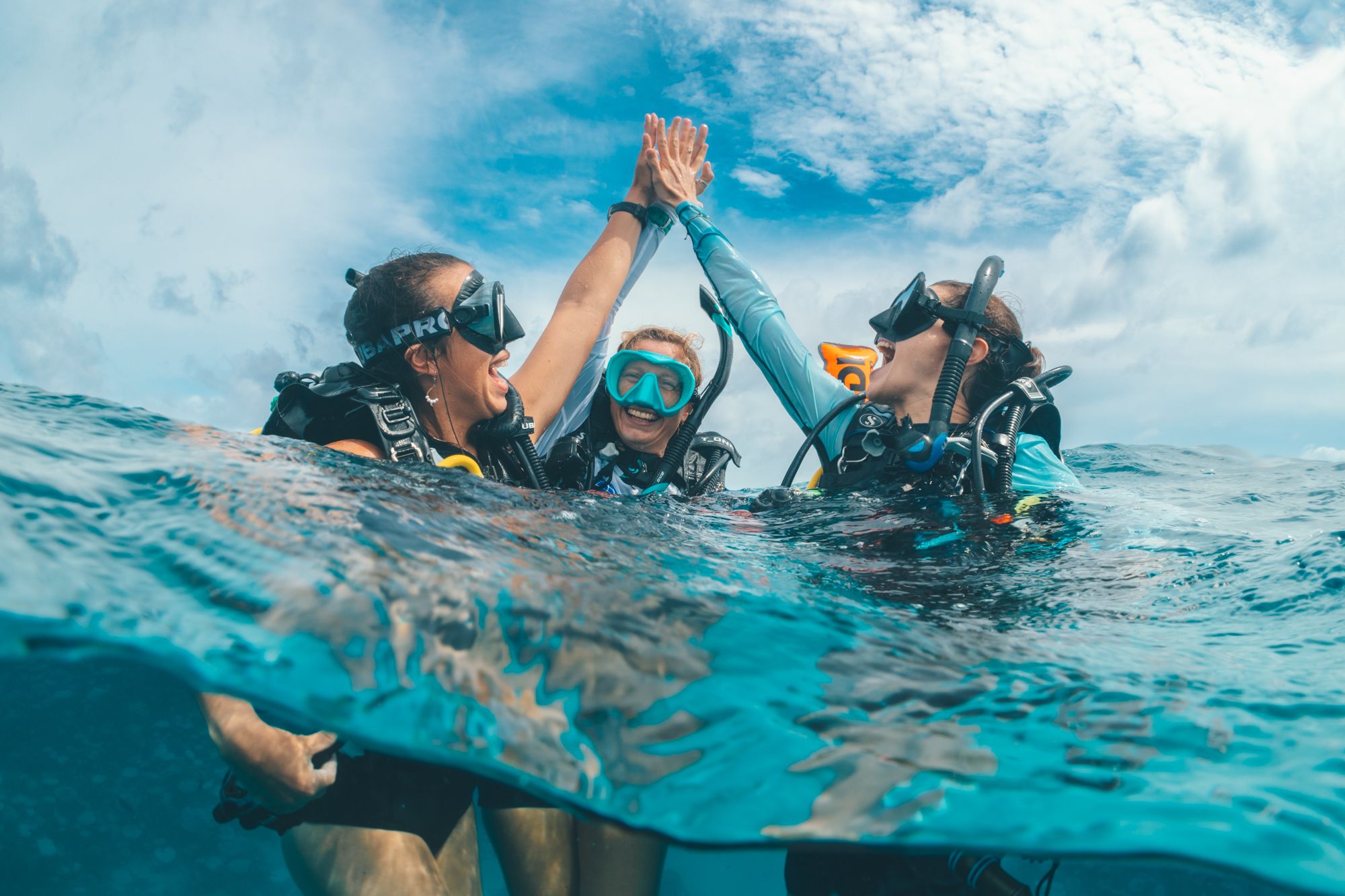 Divers high-fiving at the surface